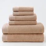 Une pile de serviettes de bain beiges soigneusement pliées, offrant une texture douce et invitante.