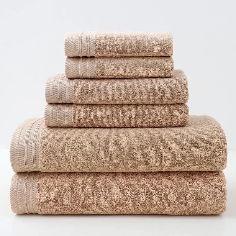 Une pile de serviettes de bain beiges soigneusement pliées, offrant une texture douce et invitante.