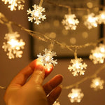 Guirlande lumineuse décorant un arbre de Noël intérieur