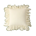 Coussin décoratif blanc moelleux avec des détails de volants verts sur les bords, créant un aspect féminin et élégant.