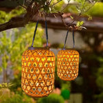 Lanterne solaire extérieur en rotin et bambou suspendue dans un jardin