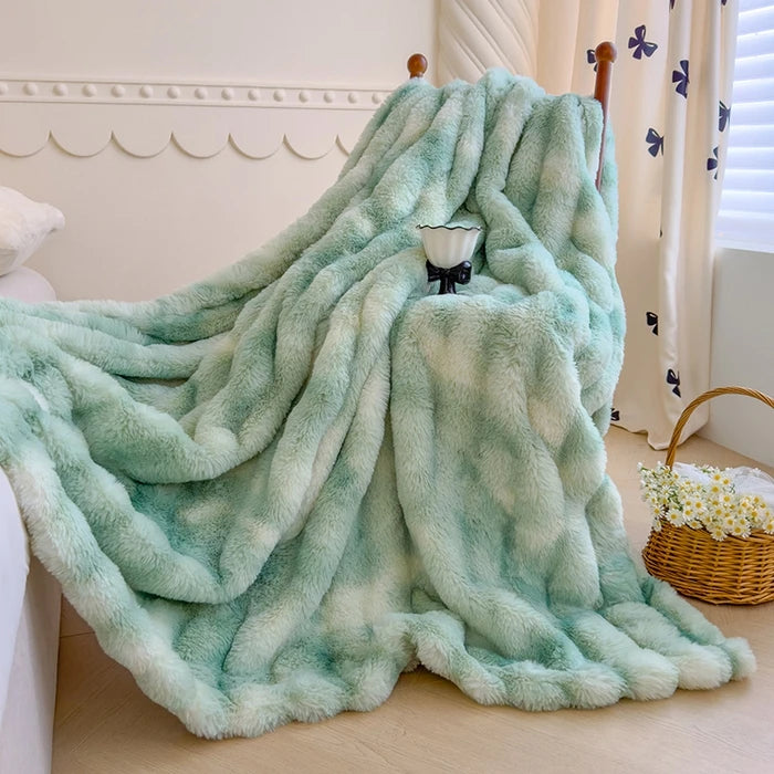 Une couverture en fourrure synthétique moelleuse de couleur vert menthe, posée sur un lit avec un panier de fleurs à côté.