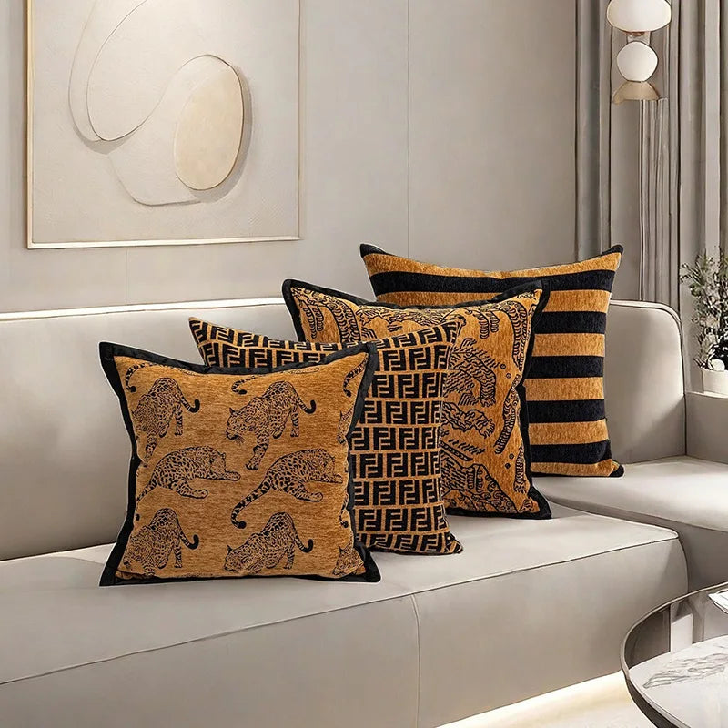 Des coussins décoratifs de style tribal avec des motifs géométriques et animaux sur un canapé blanc, créant une ambiance chaleureuse et élégante dans la pièce.