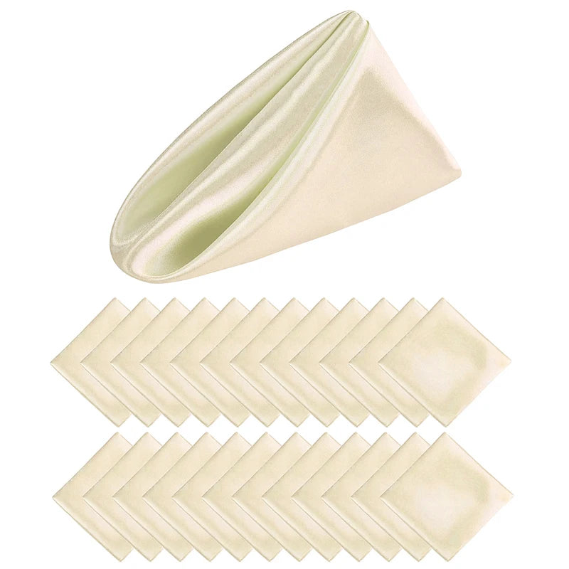 Serviettes de table pliées beige et vert clair, créant une forme géométrique.