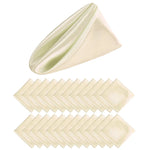 Serviettes de table pliées beige et vert clair, créant une forme géométrique.
