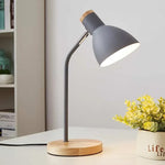 Lampe de chevet bois flexible éclairant un livre sur une table de nuit
