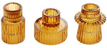 Trois photophores en verre ondulé de couleur ambre, d'aspect brillant et décoratif, idéaux pour créer une ambiance chaleureuse et réconfortante.