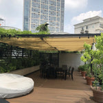 Voile d'ombrage rétractable blanche installée dans un jardin