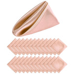 Des serviettes de table roses satinées sur fond blanc.