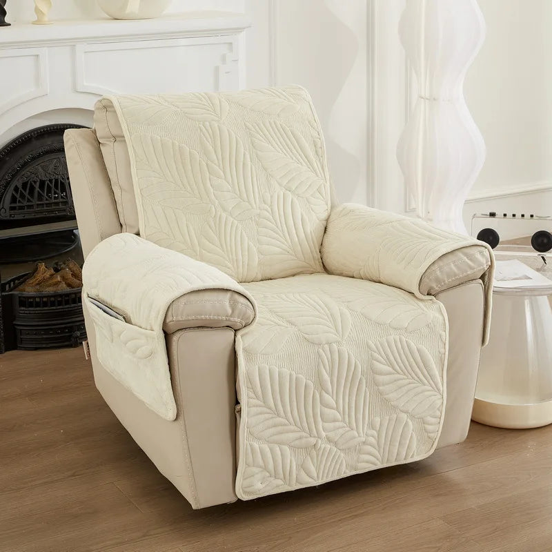 Un fauteuil confortable avec un motif de feuilles en relief, posé sur un sol en bois dans un intérieur lumineux.