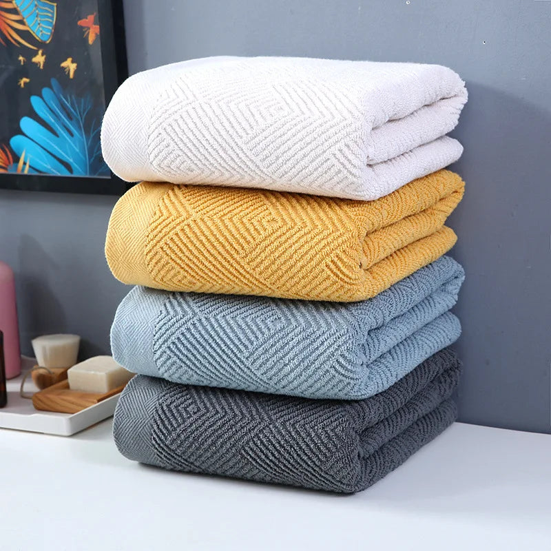 Une pile de serviettes de bain moelleuses de différentes couleurs et motifs, offrant une variété de choix pour une salle de bain accueillante.