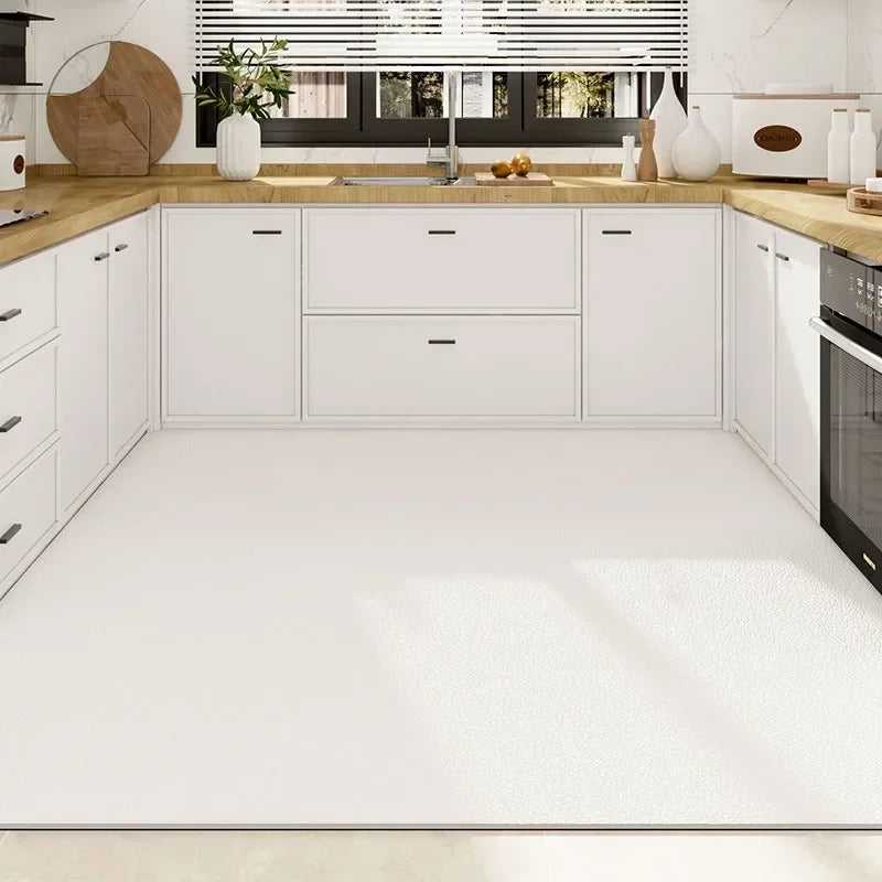 Une cuisine moderne et épurée avec des armoires blanches, un plan de travail en bois et des accents décoratifs qui créent une atmosphère chaleureuse et accueillante.