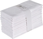 Une pile de serviettes en coton blanc pliées avec soin et une étiquette grise portant le logo de la marque.