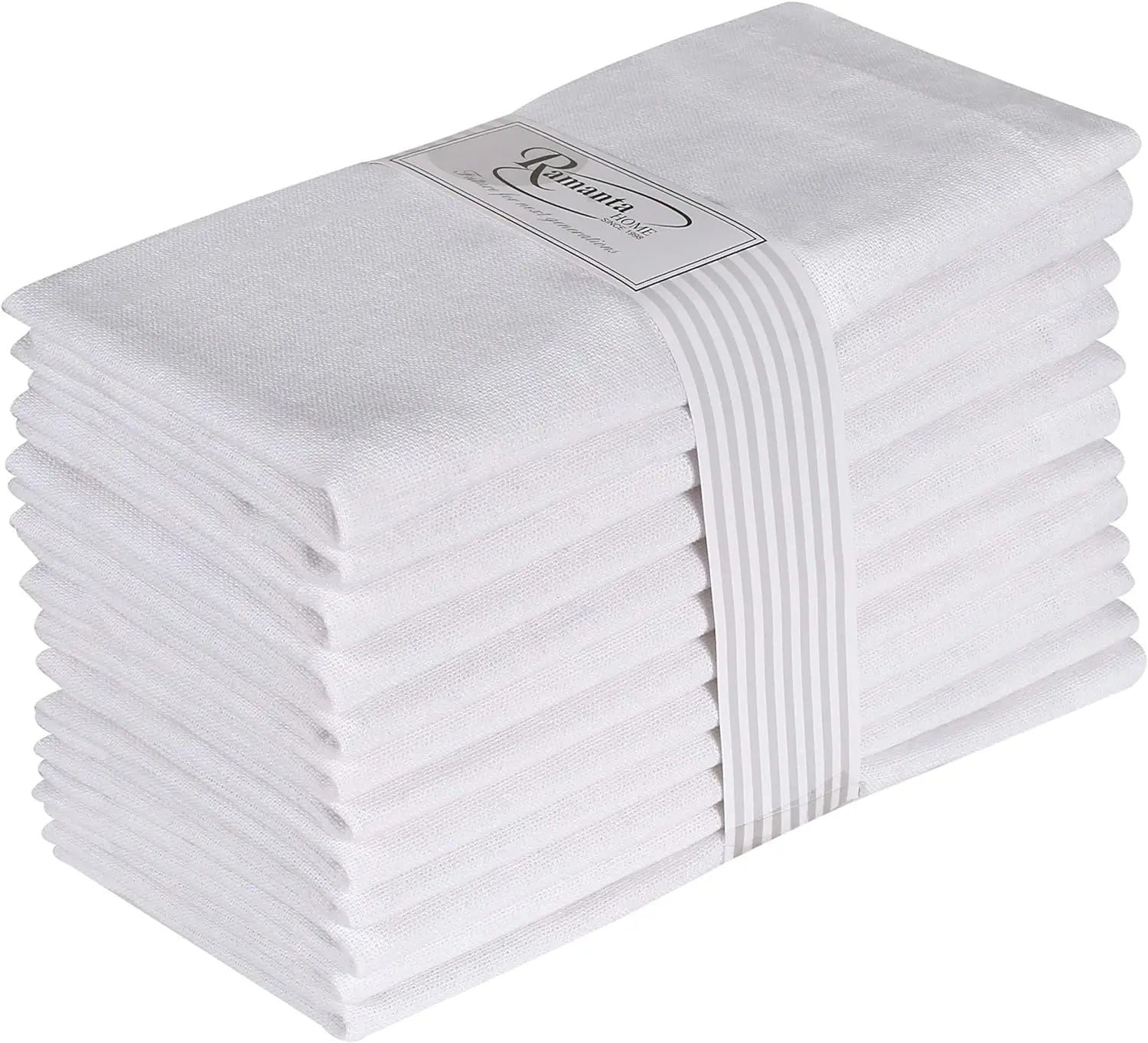 Une pile de serviettes en coton blanc pliées avec soin et une étiquette grise portant le logo de la marque.