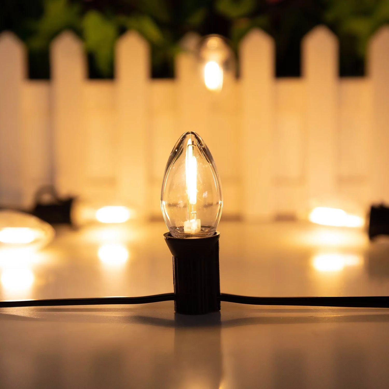 Guirlande LED C7 décorant une terrasse extérieure le soir