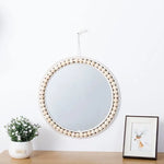 Miroir rond en rotin doré utilisé comme miroir de maquillage