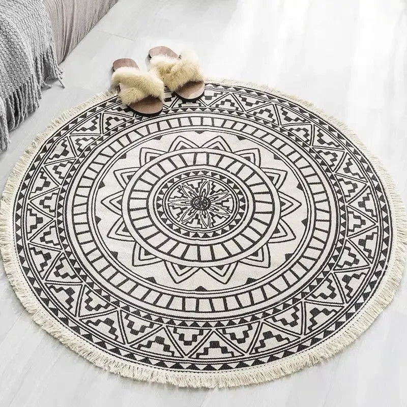 Tapis rond à motif mandala noir et blanc avec des franges, un design géométrique élégant et une texture douce pour une décoration intérieure apaisante.