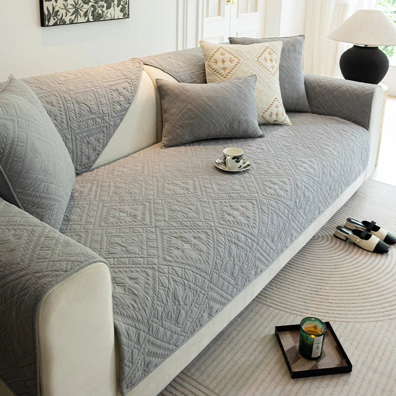 Cette image montre un canapé douillet gris et beige avec des coussins décoratifs dans un salon lumineux.