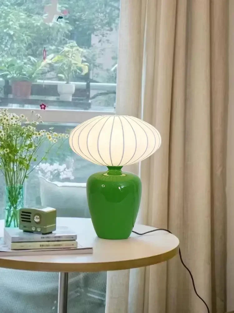 Lampe de chevet ancienne en céramique beige près d'un lit
