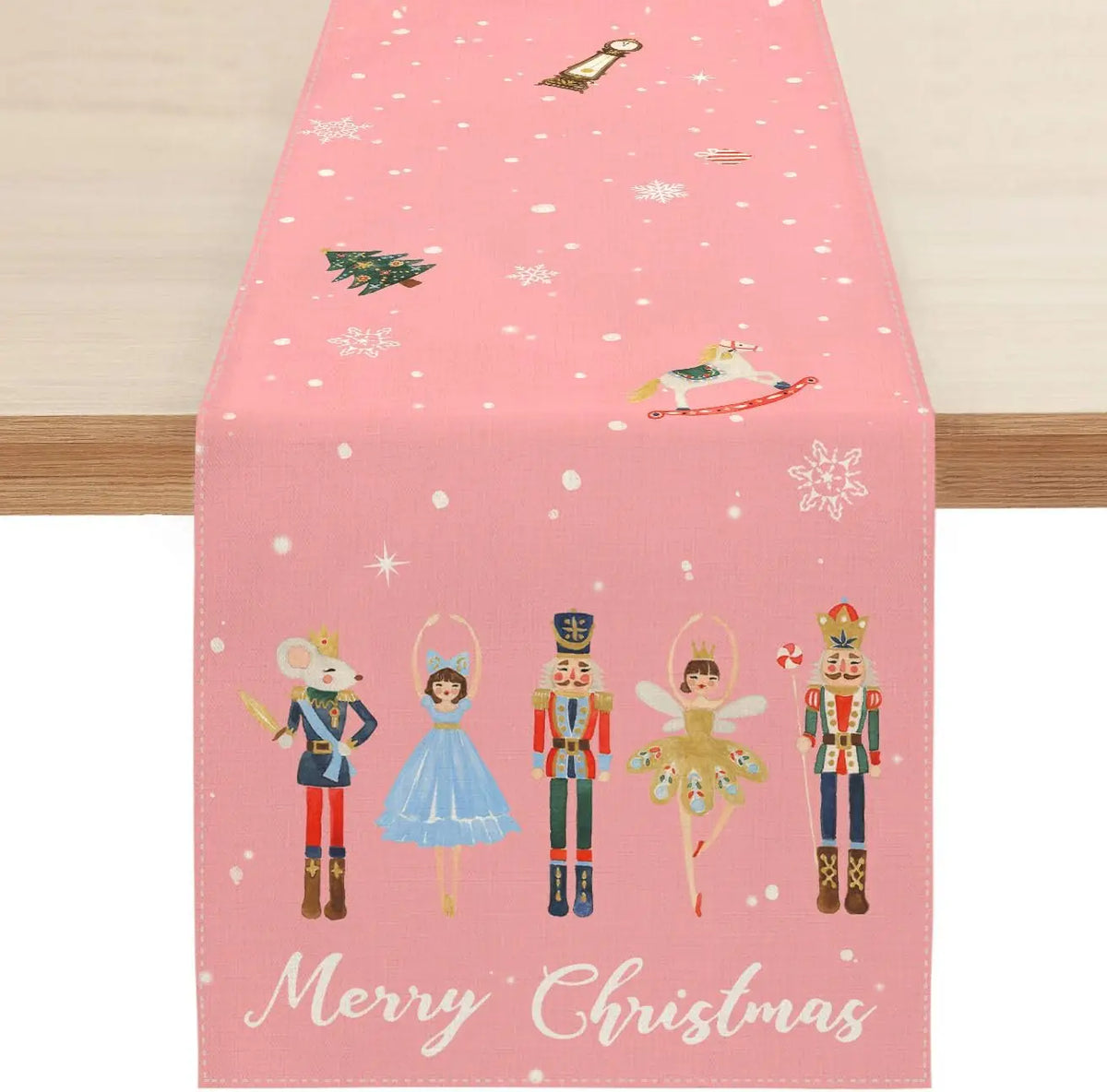 Une nappe de table de Noël rose décorée de figurines féériques comme le casse-noisette, la fée, la danseuse et le soldat, créant une atmosphère enchantée pour les fêtes de fin d'année.