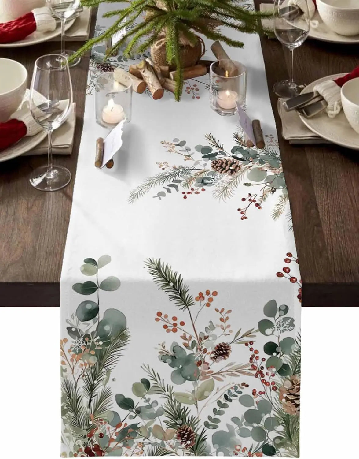 Une nappe de table blanche ornée de motifs naturels hivernaux tels que des branches de sapin, des baies rouges et des cônes de pin, créant une atmosphère festive pour une réception.
