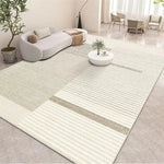 L'image montre un intérieur lumineux et épuré avec un grand tapis motif rayé blanc et gris au centre de la pièce, entouré de meubles et décorations dans des tons neutres, créant une atmosphère apaisante et élégante.