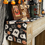 Une scène d'Halloween avec des citrouilles, des squelettes et des éléments décoratifs effrayants sur une commode en bois.