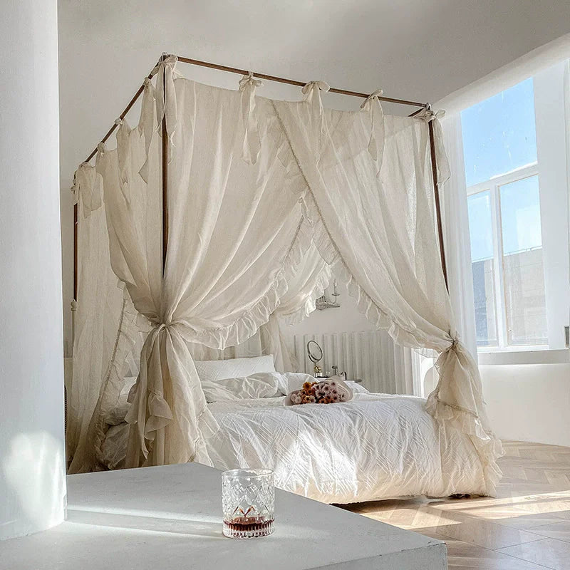 La chambre à coucher dispose d'un grand lit à baldaquin recouvert d'un drapé blanc, créant une ambiance romantique et tranquille.