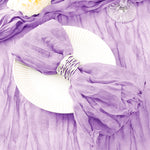 Une ravissante nappe en voile de couleur lavande, agrémentée d'un bouquet de fleurs blanches, créant une élégante mise en scène pour une table de fête.