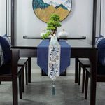 Intérieur moderne avec mobilier en bois sombre, décoration asiatique et miniature d'arbre dans un décor montagneux.