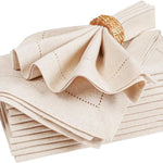 Serviettes de table beiges en lin naturel avec motifs cousus et panier en osier.