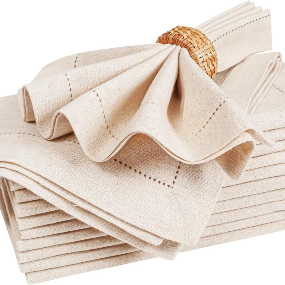 Serviettes de table beiges en lin naturel avec motifs cousus et panier en osier.