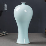 Vase décoratif en céramique blanche brillante avec une forme élancée et une finition lisse.