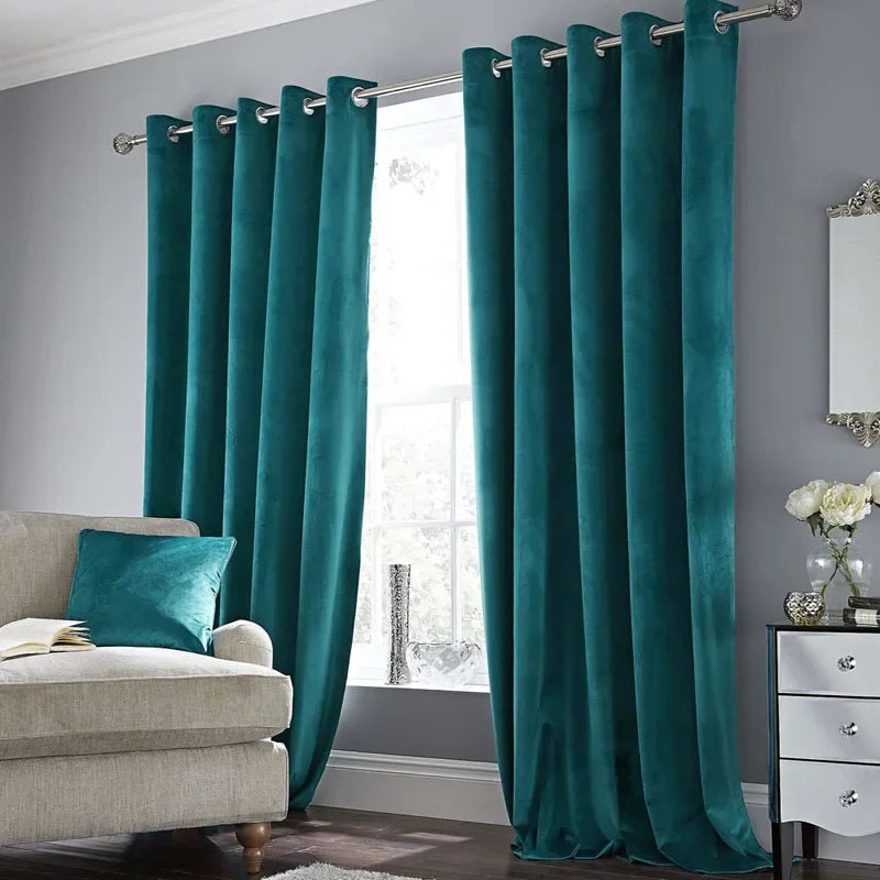 Élégants rideaux en velours vert, suspendus dans un salon contemporain pour une fenêtre avec un traitement de fenêtre sophistiqué. Les rideaux ajoutent une touche de luxe à l'intérieur de la pièce qui est accentuée par des meubles design et des plantes d'intérieur. L'image illustre l'utilisation des rideaux comme revêtement de fenêtre pour améliorer le design d'intérieur.