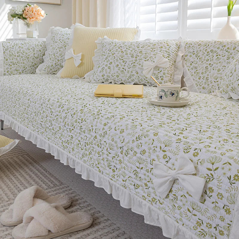 Un lit douillet et confortable avec des draps blancs fleuris, des oreillers moelleux et des accessoires décoratifs élégants créant une atmosphère apaisante et chaleureuse dans cette chambre spacieuse et lumineuse.