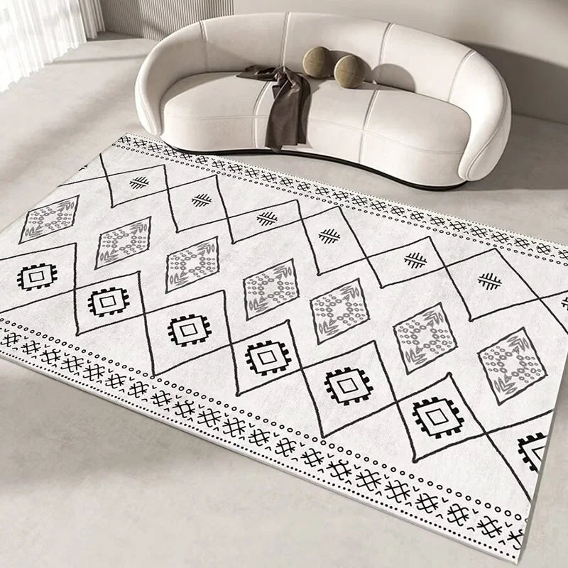 Tapis de sol à motifs géométriques monochromes, avec des carrés et des formes triangulaires, créant un design abstrait et épuré dans les tons de noir et blanc.