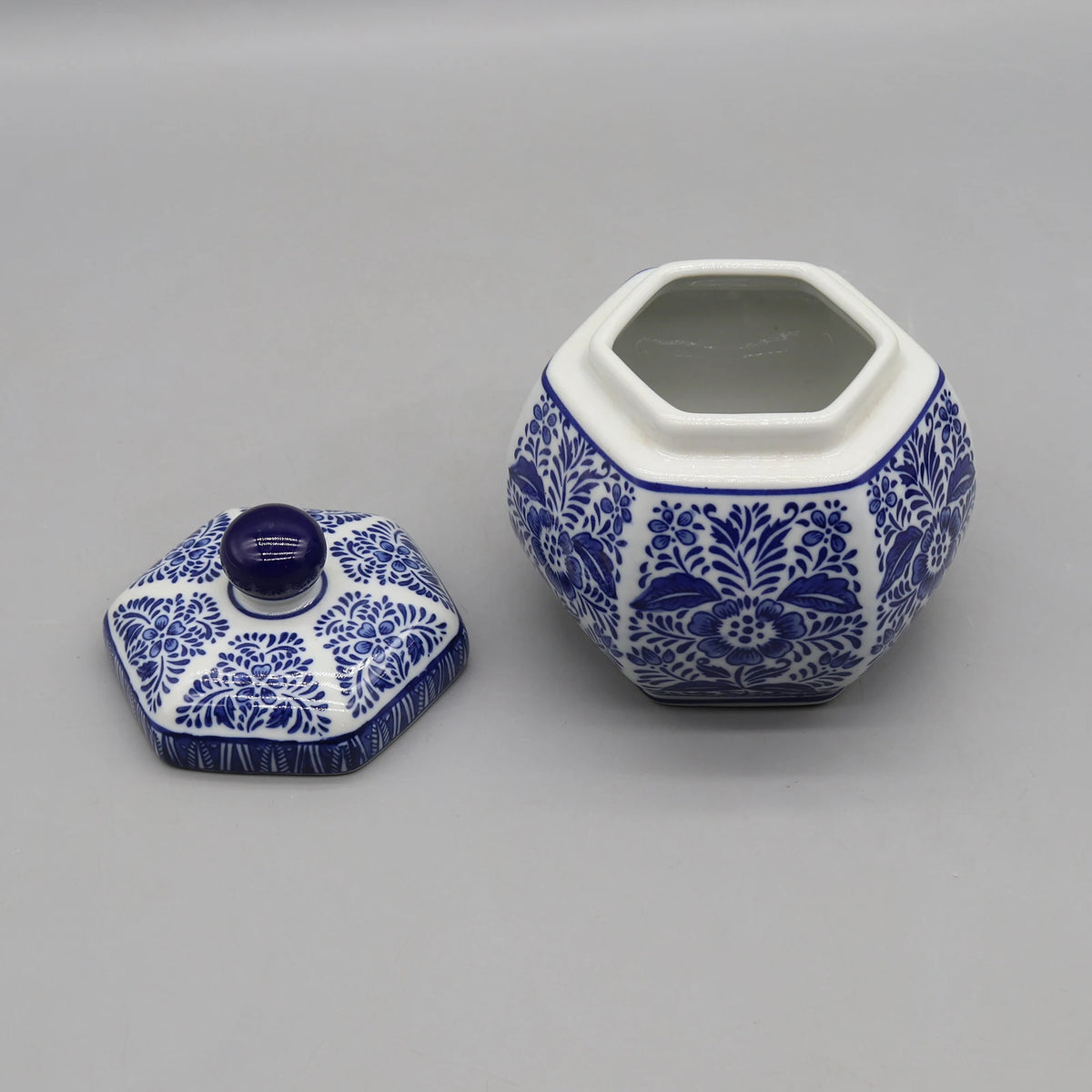 Pot en céramique décoratif hexagonal bleu et blanc avec couvercle, orné de motifs floraux traditionnels.