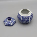 Pot en céramique décoratif hexagonal bleu et blanc avec couvercle, orné de motifs floraux traditionnels.