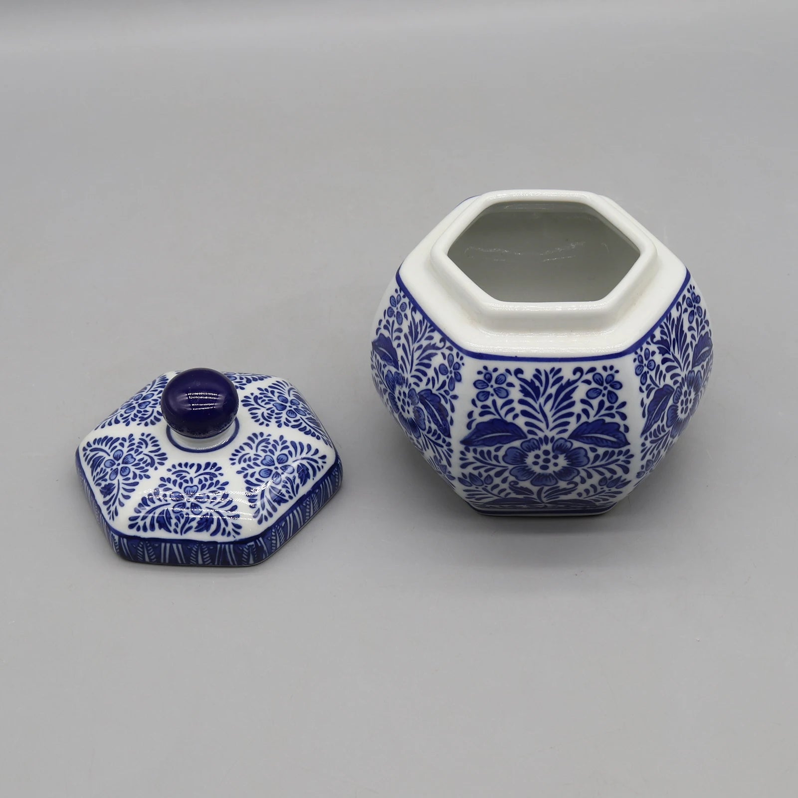 Pot en céramique décoratif hexagonal bleu et blanc avec couvercle, orné de motifs floraux traditionnels.