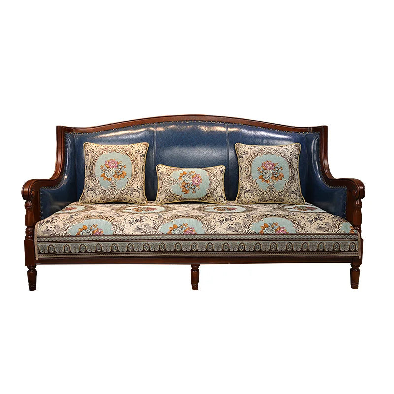 Un canapé en bois sombre avec un motif de fleurs dans des tons pastel et un rembourrage en cuir bleu marine.