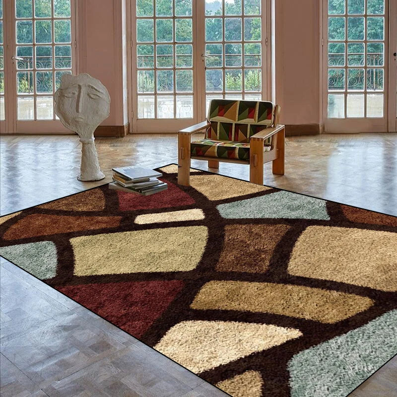 L'image montre une pièce lumineuse avec de grandes fenêtres donnant sur un environnement verdoyant. Un fauteuil en bois avec un motif coloré et une sculpture géométrique se trouvent sur un tapis aux motifs abstraits et aux couleurs chaleureuses.