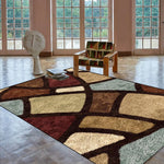 L'image montre une pièce lumineuse avec de grandes fenêtres donnant sur un environnement verdoyant. Un fauteuil en bois avec un motif coloré et une sculpture géométrique se trouvent sur un tapis aux motifs abstraits et aux couleurs chaleureuses.