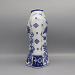 Vase en porcelaine blanche avec des motifs floraux bleus délicats et élégants, créant un contraste saisissant avec son fond clair.