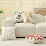Un salon confortable avec des coussins décoratifs aux motifs géométriques et des touches de couleurs chaudes dans un décor épuré.
