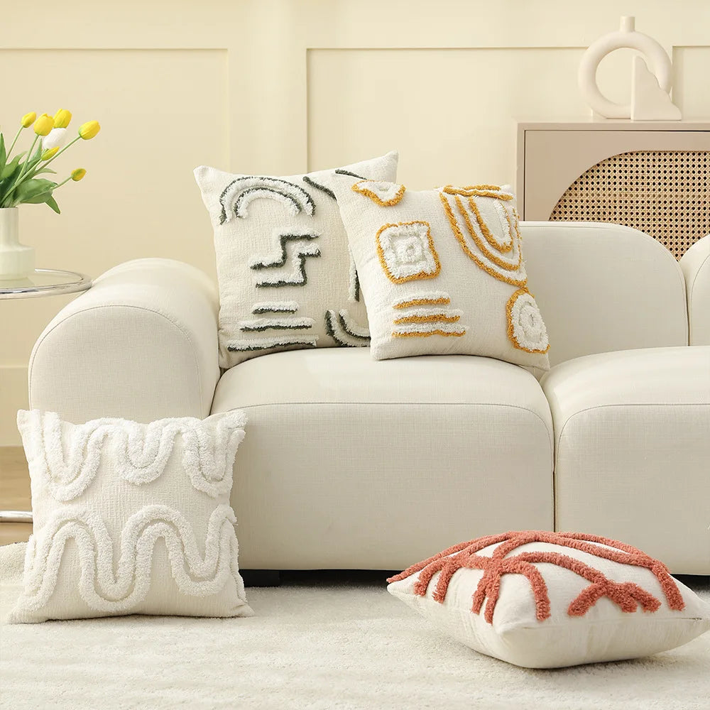 Un salon confortable avec des coussins décoratifs aux motifs géométriques et des touches de couleurs chaudes dans un décor épuré.