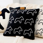 Coussin décoratif avec motif graphique en noir et blanc, créant un design moderne et élégant parfait pour agrémenter un intérieur.