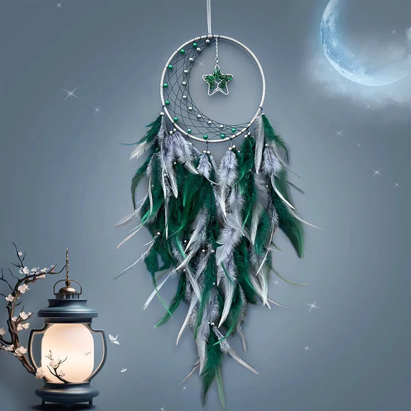 Attrapeur de rêves décoratif en plumes grises et vertes, avec une lune et des étoiles brillantes dans un ciel nocturne sombre, créant une atmosphère apaisante et mystique.
