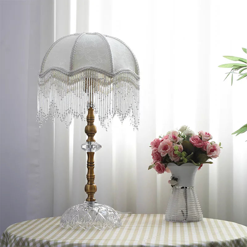 Détail de l'abat-jour en velours vert avec franges décoratives