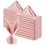 Une pile de serviettes de table roses en satin, pliées avec soin, forme un élément décoratif élégant et texturé.