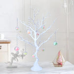 Sapin de Noël blanc et or de 72cm sur une table à gâteau décorée